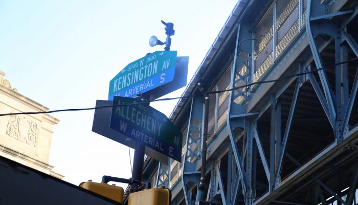Street signs for Kensington Avenue and Allegheny Avenue beneath an elevated railway